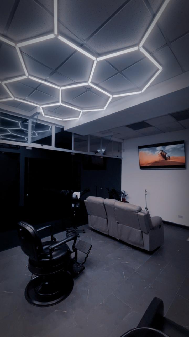 Estación de corte de THE SITE STUDIO BARBER, con iluminación LED hexagonal